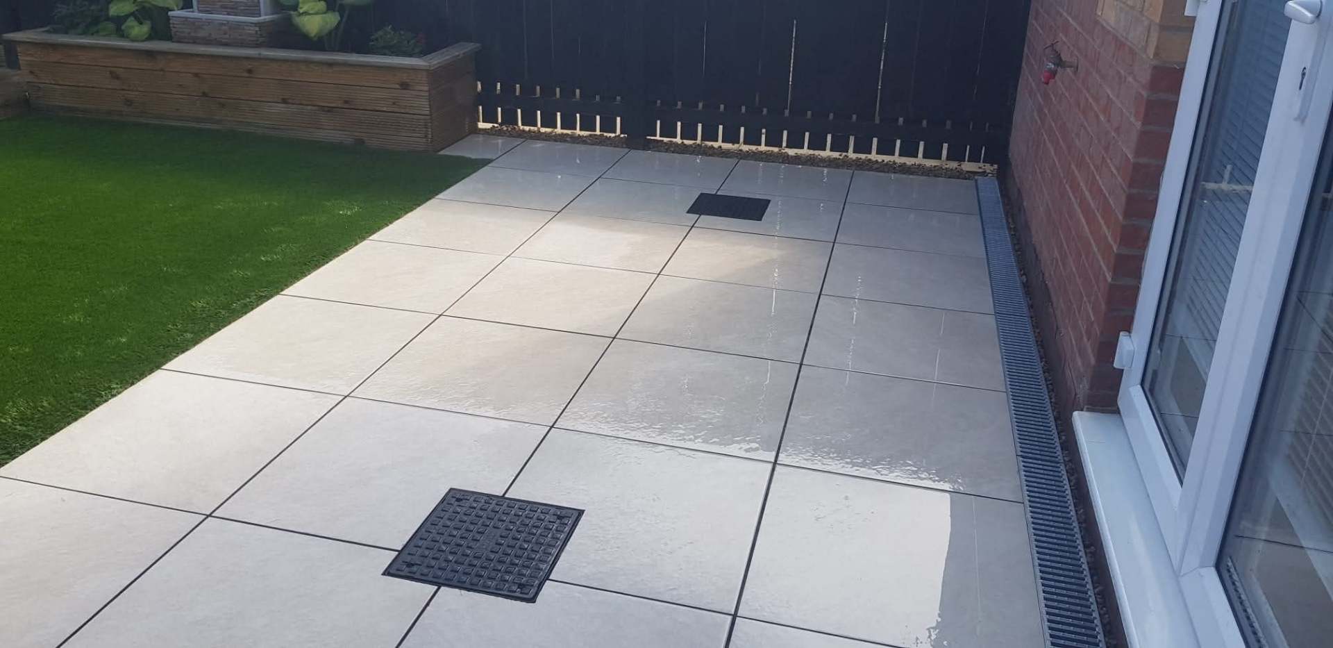 Porcelain patio with outdoor kitchen and pizza oven installed by E.R.D Paving